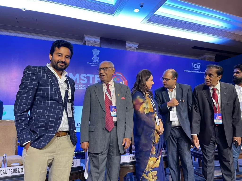 Participants standing beside the BIMSTEC Business Summit stage.