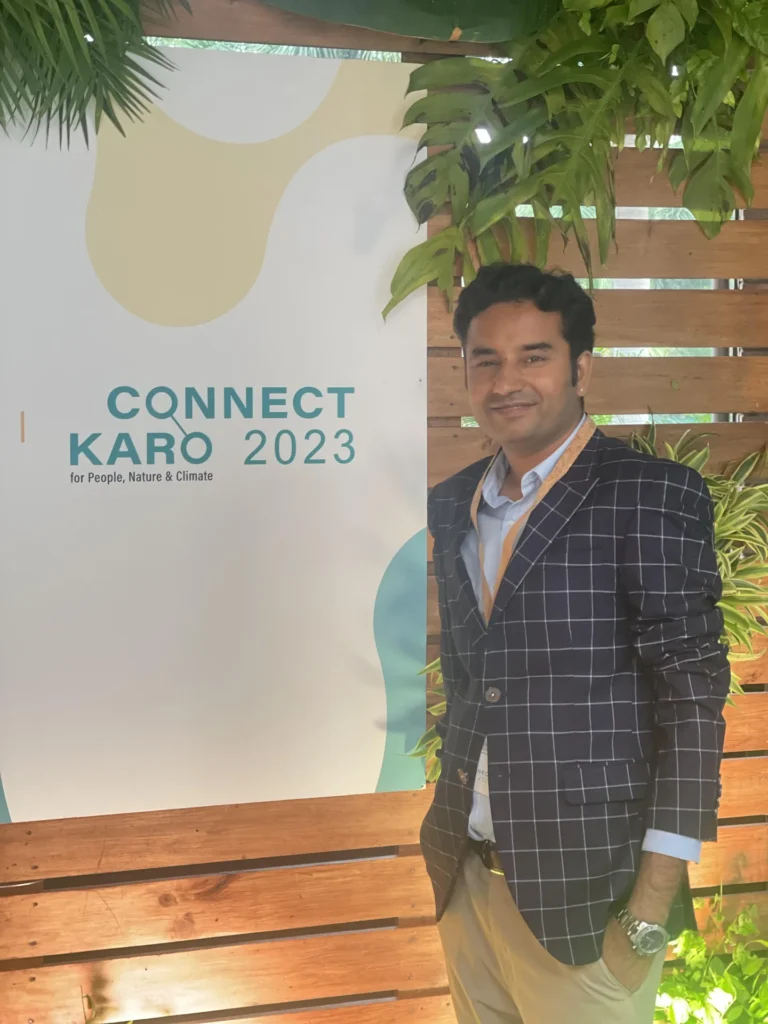 An attendee beside a Connect Karo 2023 sign.