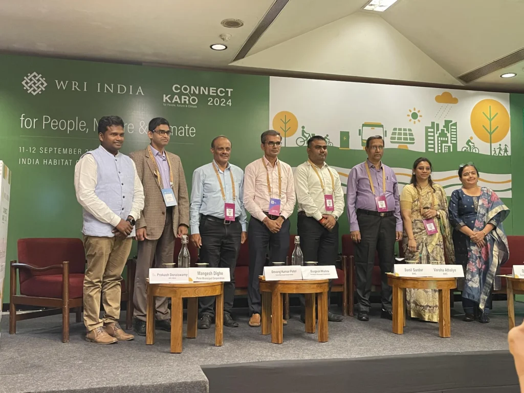 Participants holding publications beneath the Connect Karo 2024 backdrop.