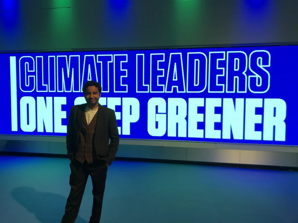 An attendee beneath the Climate Leaders One Step Greener display.