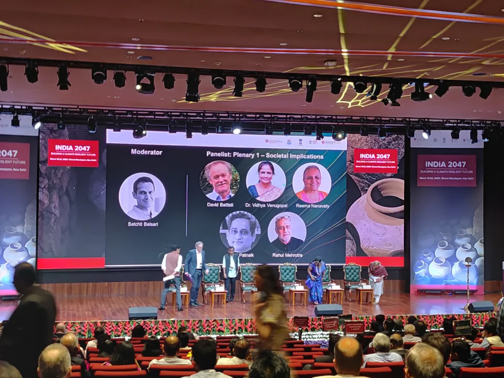 A wide view of the conference panel and seated audience.