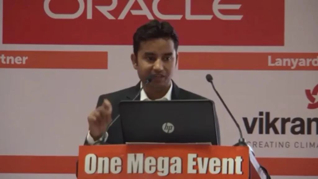 A speaker presenting behind a laptop at the One Mega Event lectern.