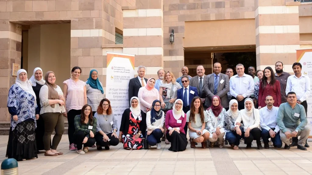 Workshop participants posing together outside the university building.