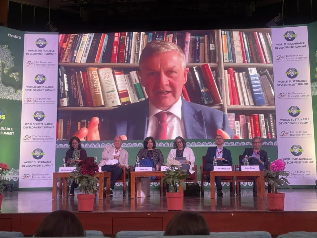 Panel members watching a remote speaker on the summit screen.