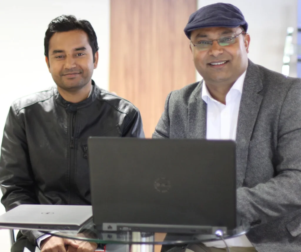 Two participants seated together behind a laptop.
