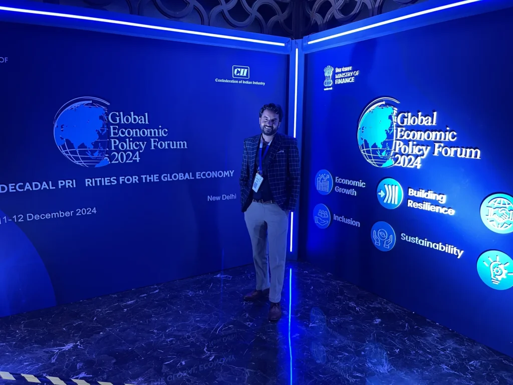 An attendee beside the Global Economic Policy Forum 2024 backdrop.