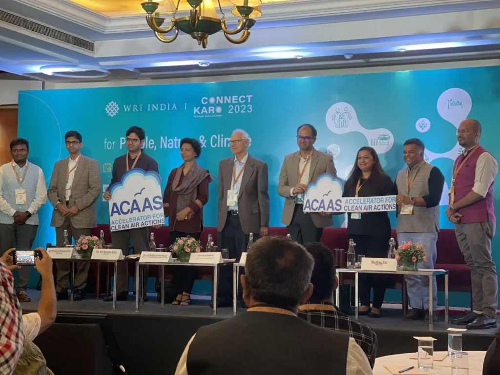 Participants holding ACAAS signs on the Connect Karo 2023 stage.