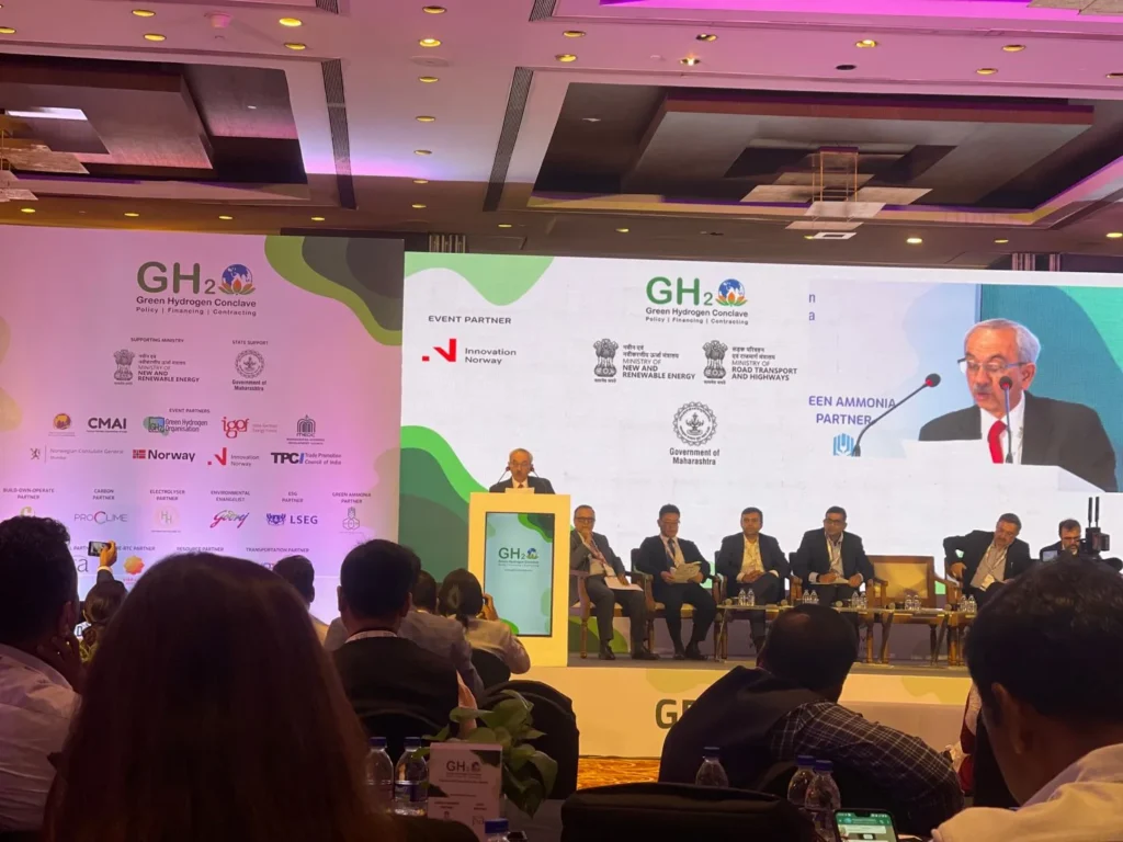 A speaker and panel beneath the Green Hydrogen Conclave stage screen.