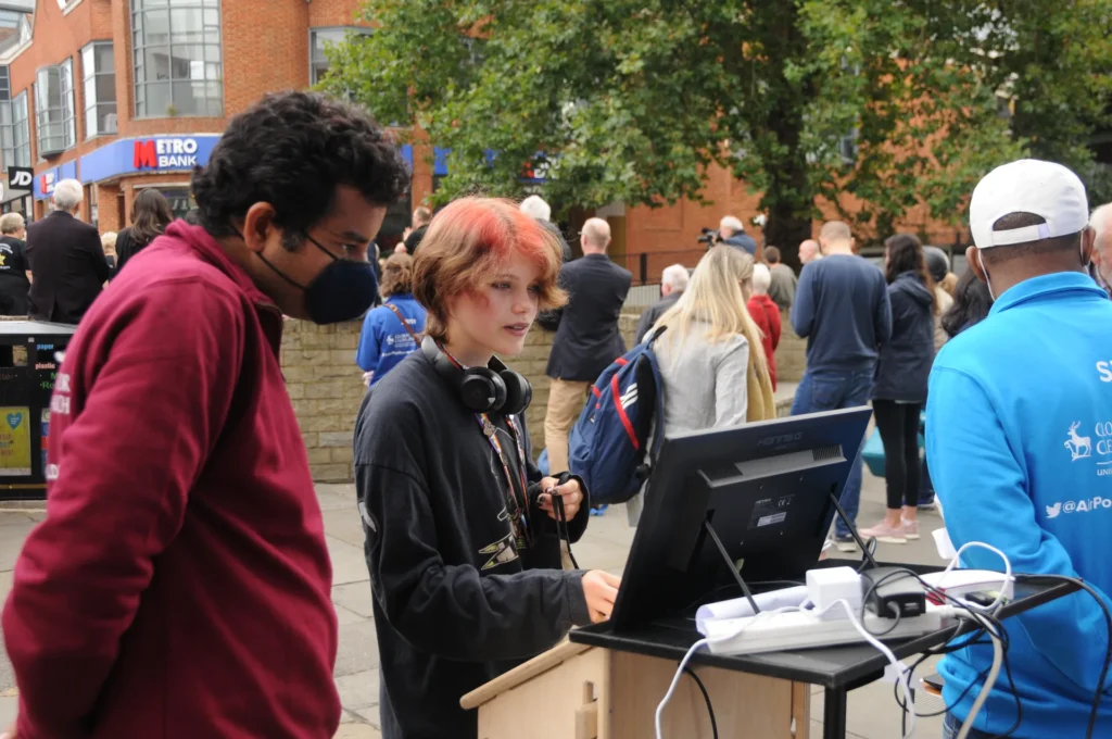 A researcher demonstrating a computer-based activity to a visitor.