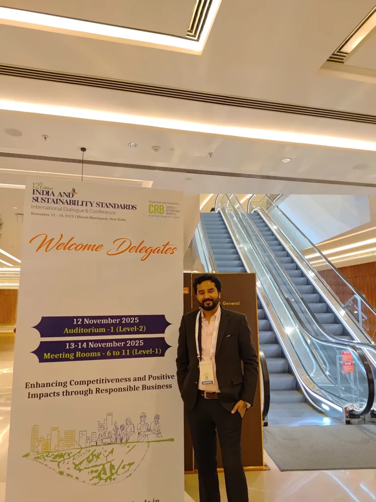 An attendee beside the India and Sustainability Standards programme sign.