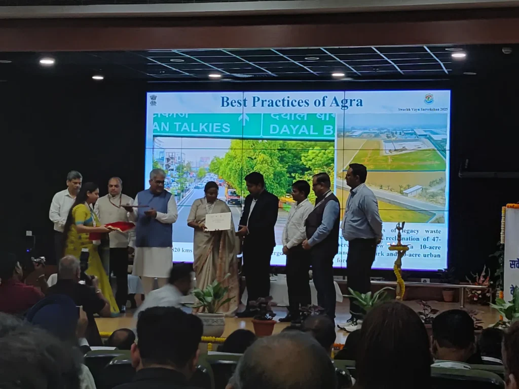 Representatives on stage beneath the Best Practices of Agra screen.