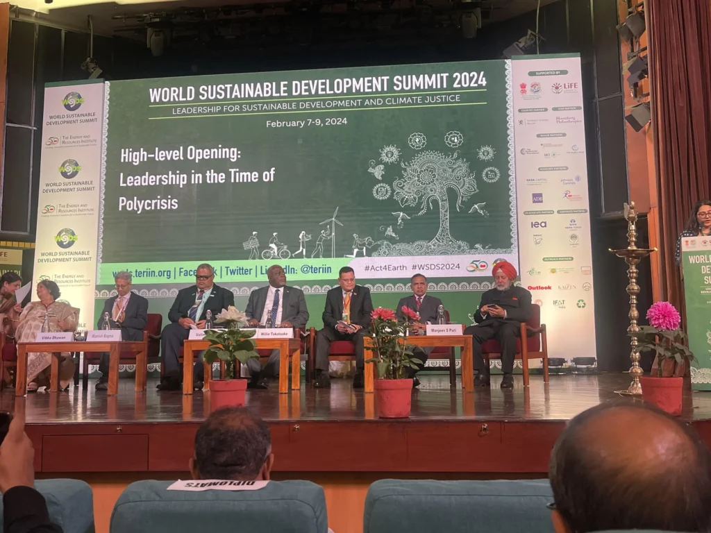Panel members beneath the World Sustainable Development Summit 2024 opening screen.