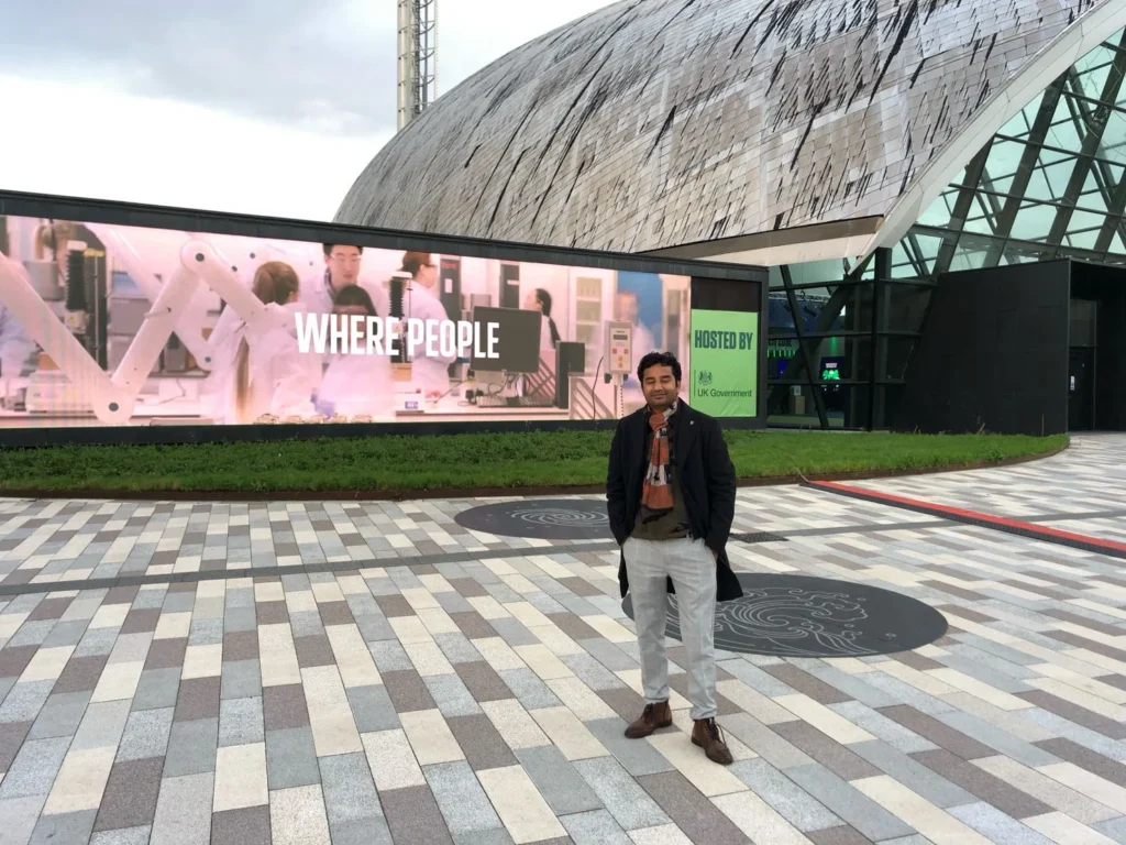 An attendee outside the venue beside the Where People display.