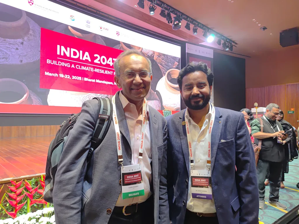 Two participants standing beside the India 2047 conference stage.