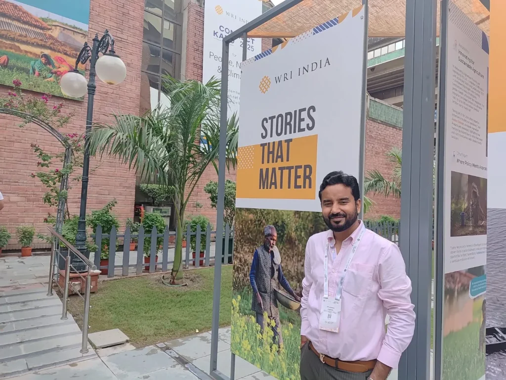 An attendee beside the WRI India Stories That Matter exhibition display.