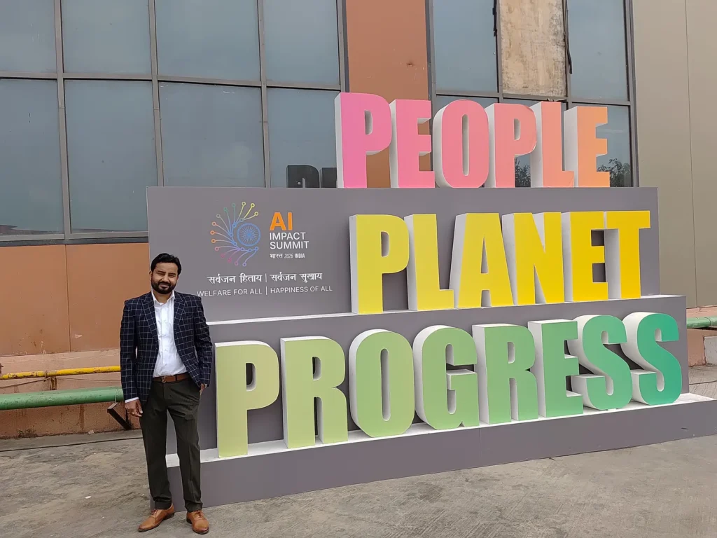 An attendee beside the People, Planet, Progress installation at the AI Impact Summit.
