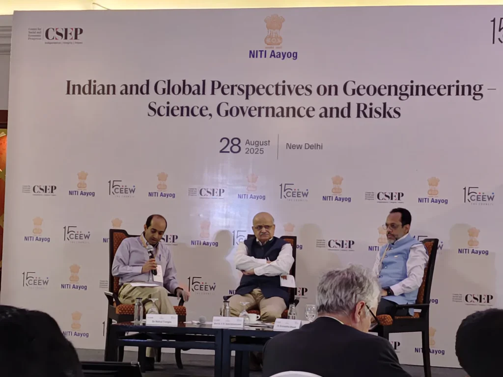 Three panel members discussing geoengineering beneath the event banner.