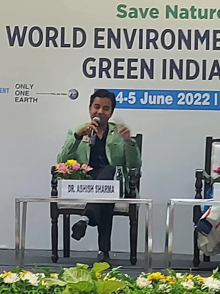 A seated speaker holding a microphone during a conference session.