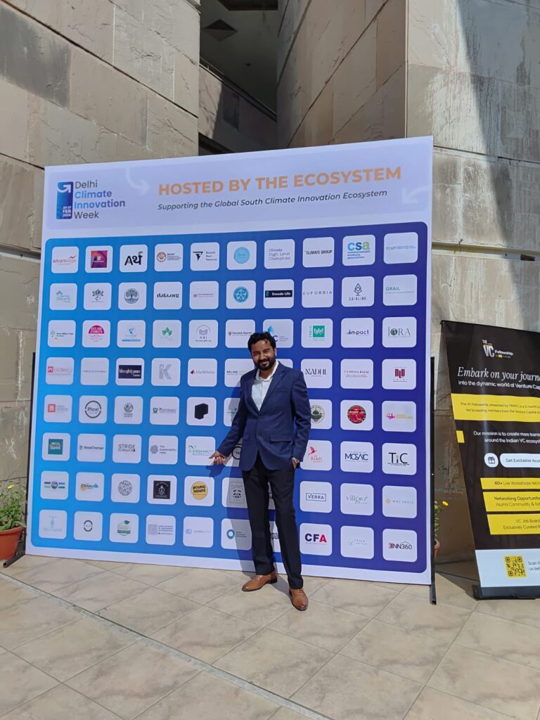 Dr. Ashish Sharma beside the Delhi Climate Innovation Week ecosystem display at TERI SAS.